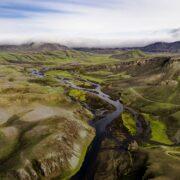 green grass field and river
