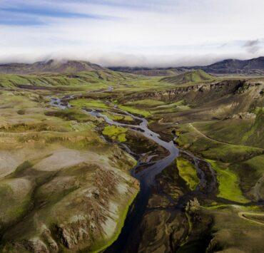 green grass field and river