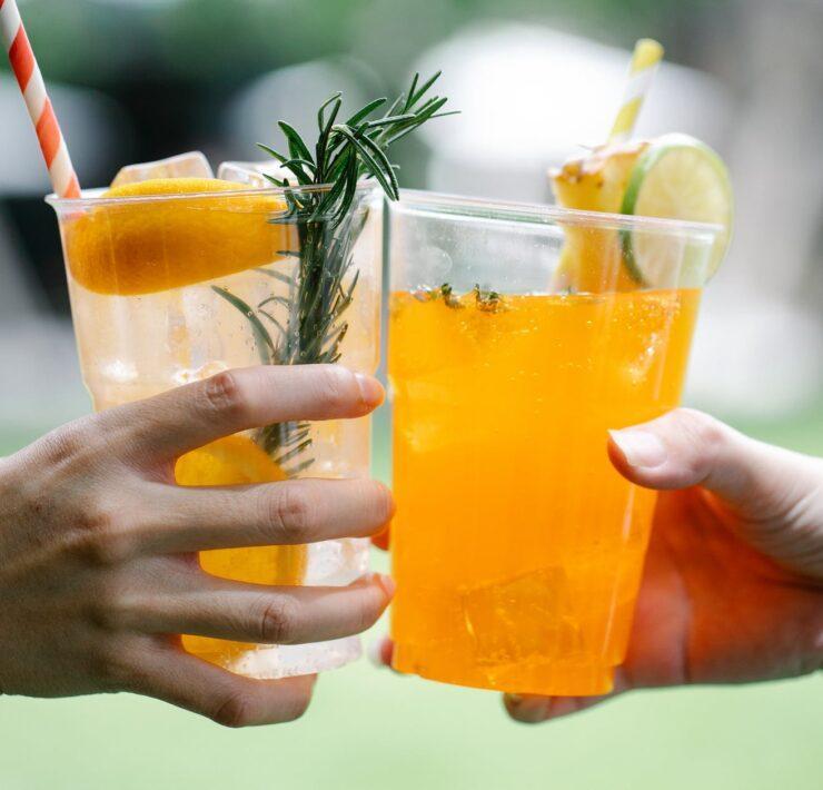 close up photo of two people toasting fruit drinks