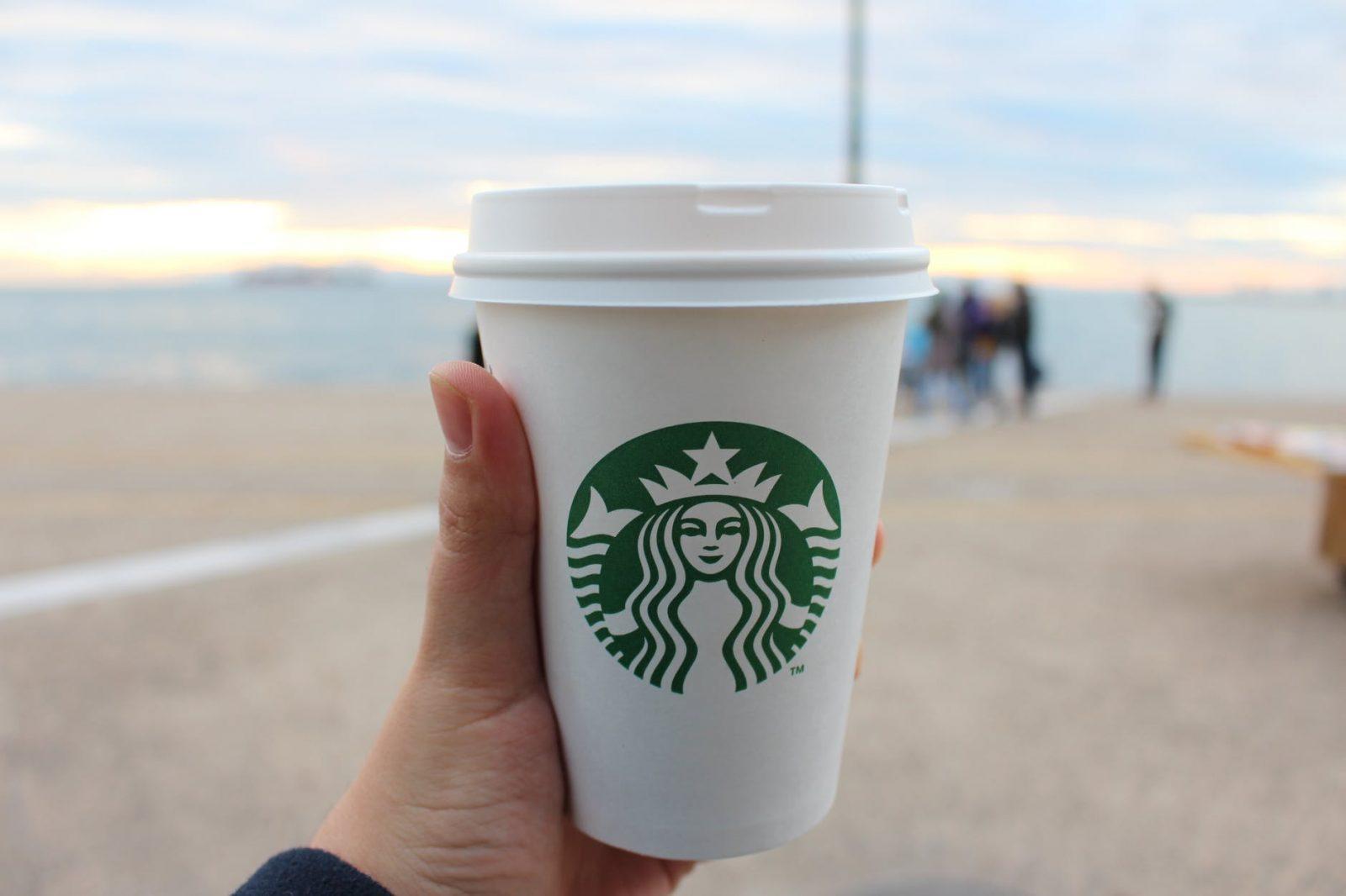 person holding star buck plastic cup