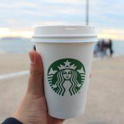 person holding star buck plastic cup