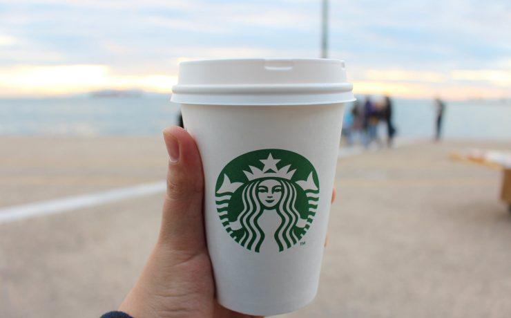 person holding star buck plastic cup