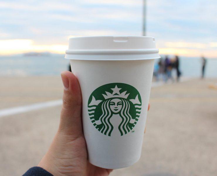 person holding star buck plastic cup