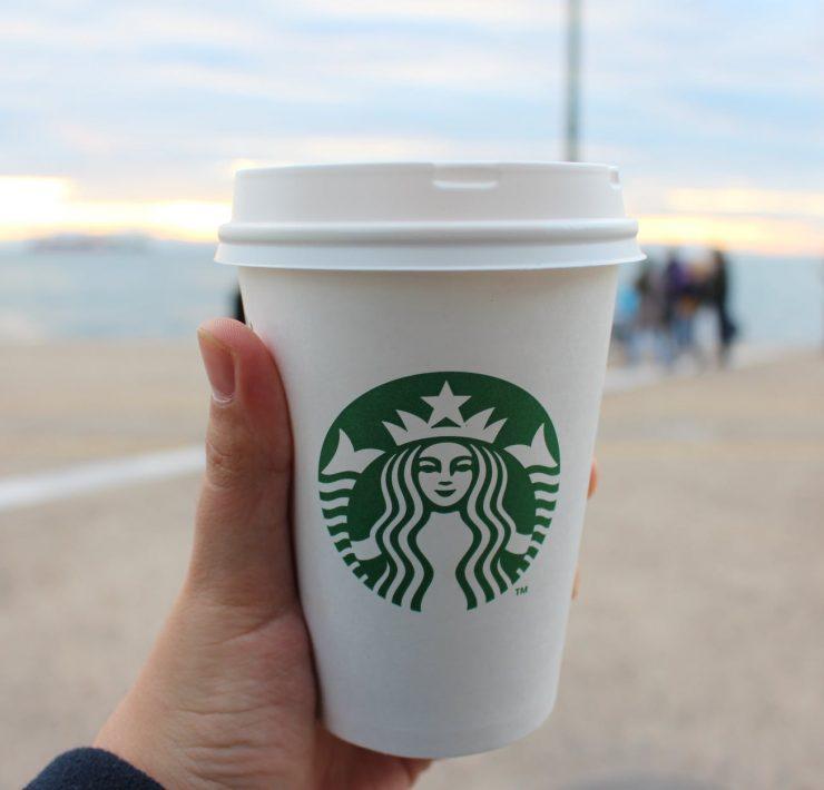 person holding star buck plastic cup