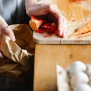 crop woman cleaning cutting board in kitchen