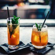 two brown liquid inside clear drinking glasses