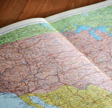 map of the world book laid open on brown wooden surface