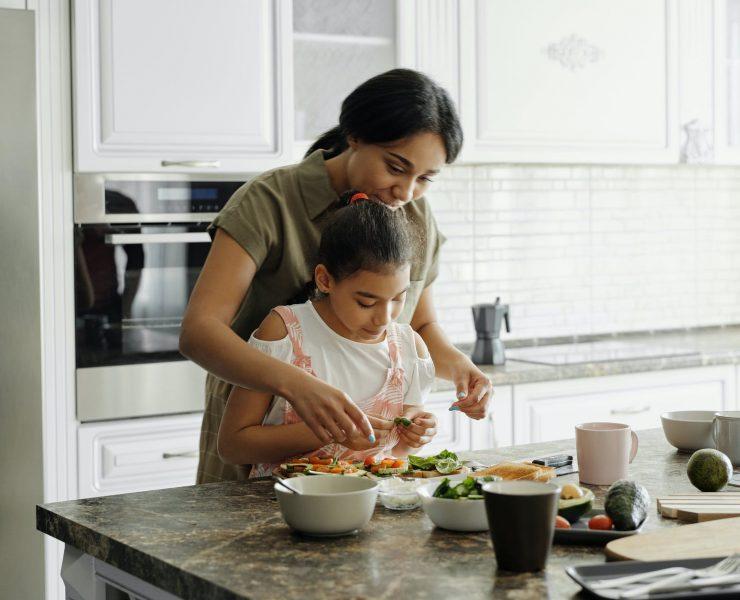 mother and daughter preparing avocado toast
