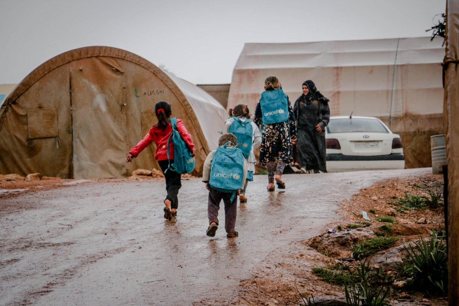 refugee children returning from school to tents
