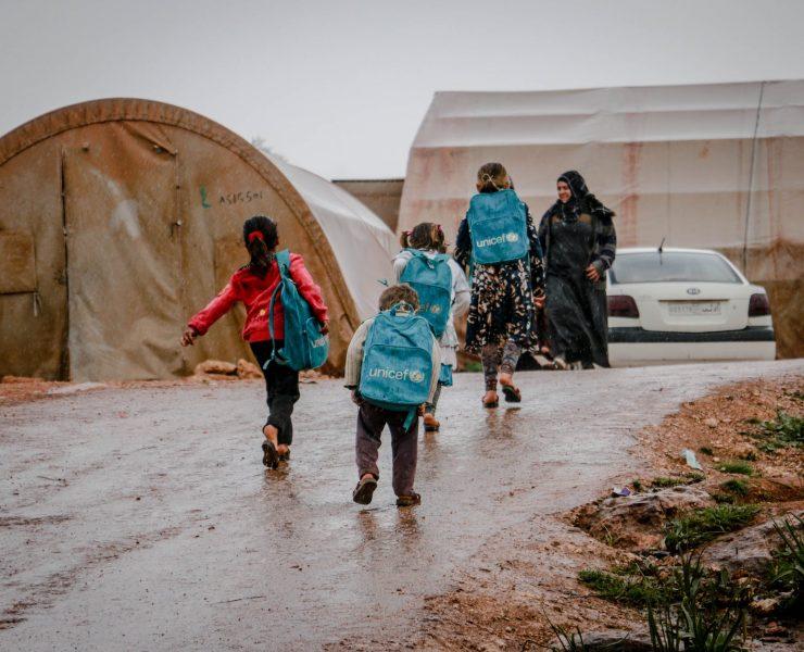 refugee children returning from school to tents