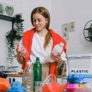 positive female sorting plastic bottles in kitchen in apartment