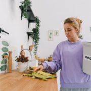 calm female sorting organic trash in kitchen in light room