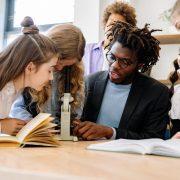 a man teaching students how to use a microscope