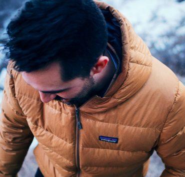 man in brown jacket looking down