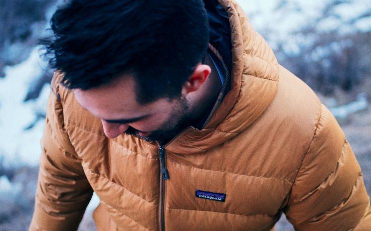 man in brown jacket looking down