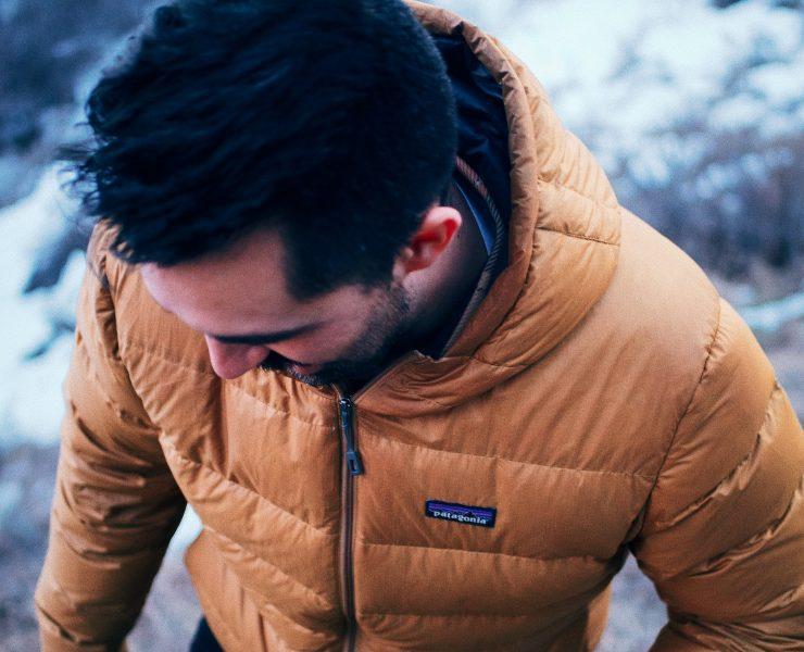 man in brown jacket looking down