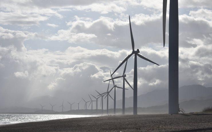 windmills on seashore under white clouds