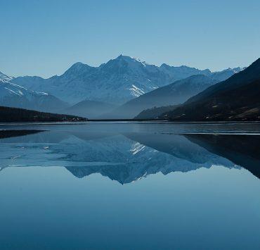 calm body of lake between mountains