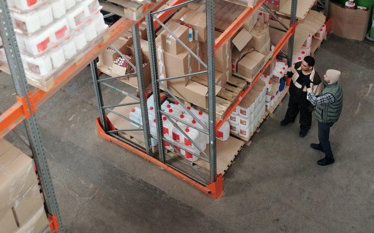 men standing in a warehouse talking