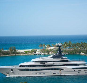 white and blue yacht on body of water