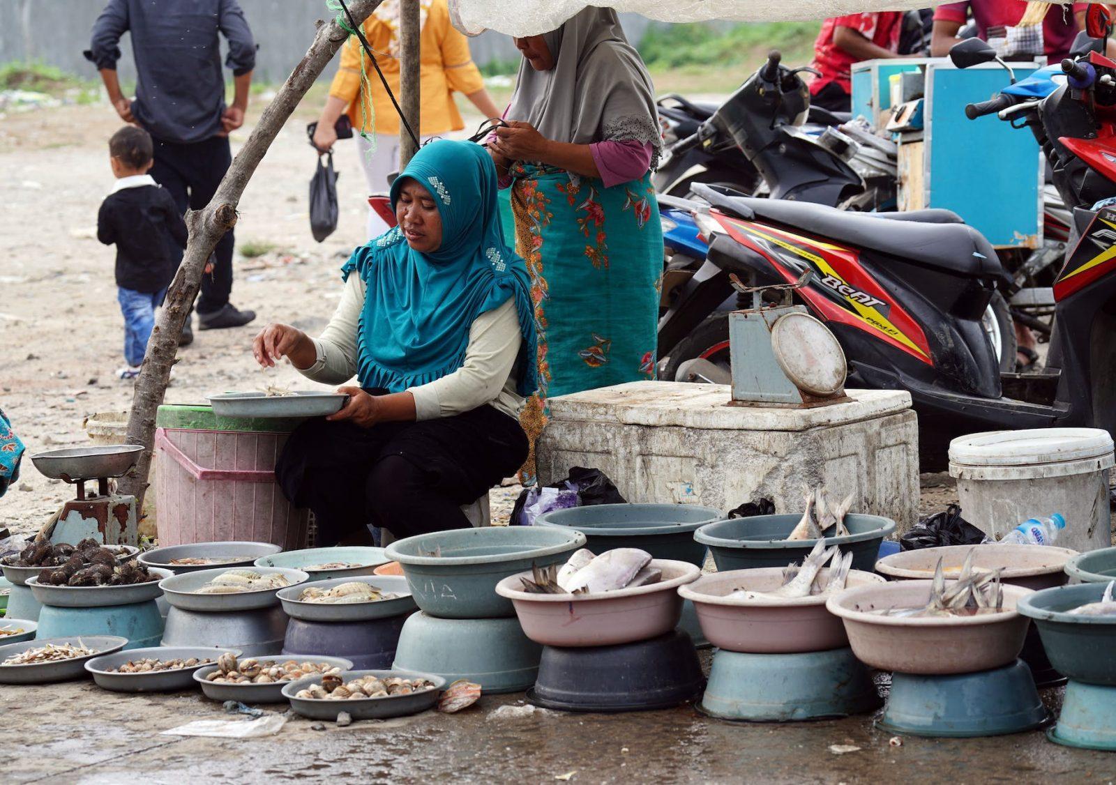 a woman selling variety of seafood on the street