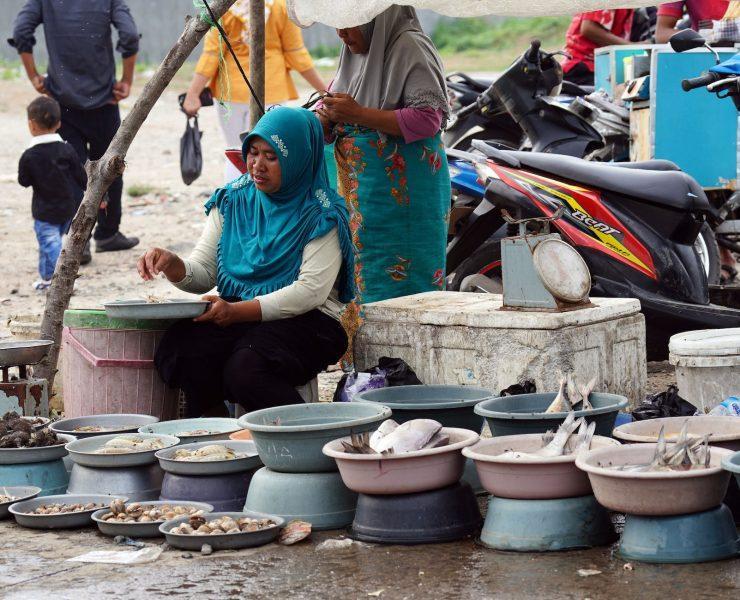 a woman selling variety of seafood on the street
