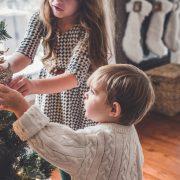boy and girl decorating Christmas tree inside room