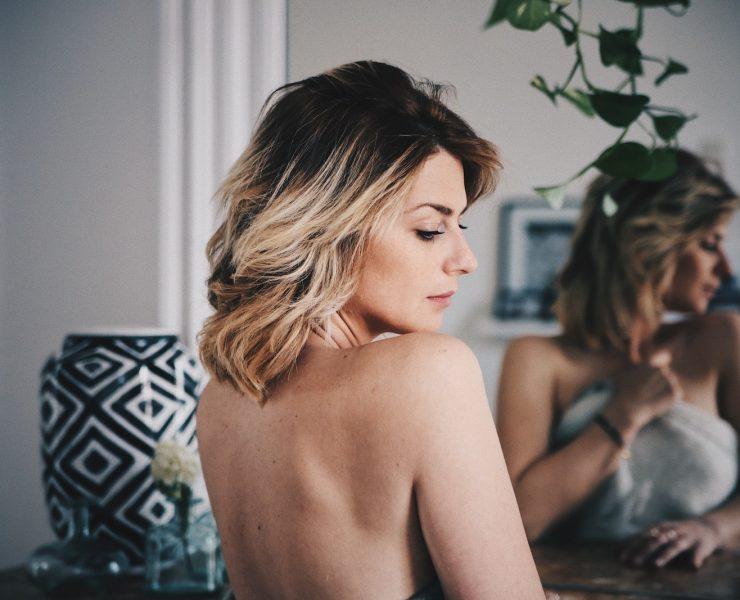 woman with blonde hair covering her body with white towel
