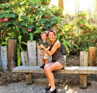 woman in black tank top sitting on brown wooden bench