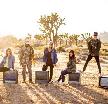 group of six people standing on desert