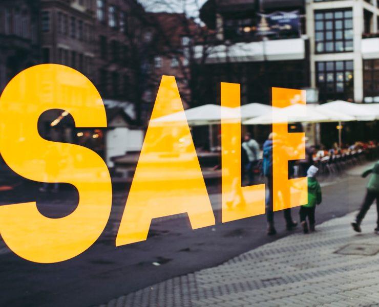 man in green jacket walking on sidewalk during daytime