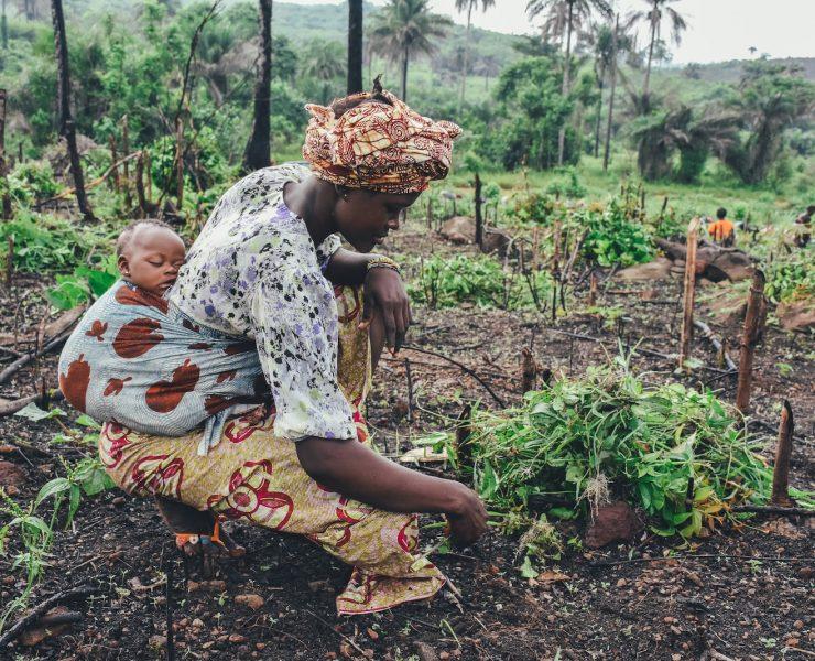 women carrying baby in her back close-up photography