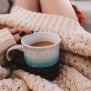 white ceramic mug on white knit textile