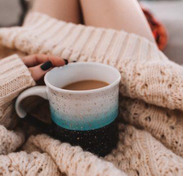 white ceramic mug on white knit textile