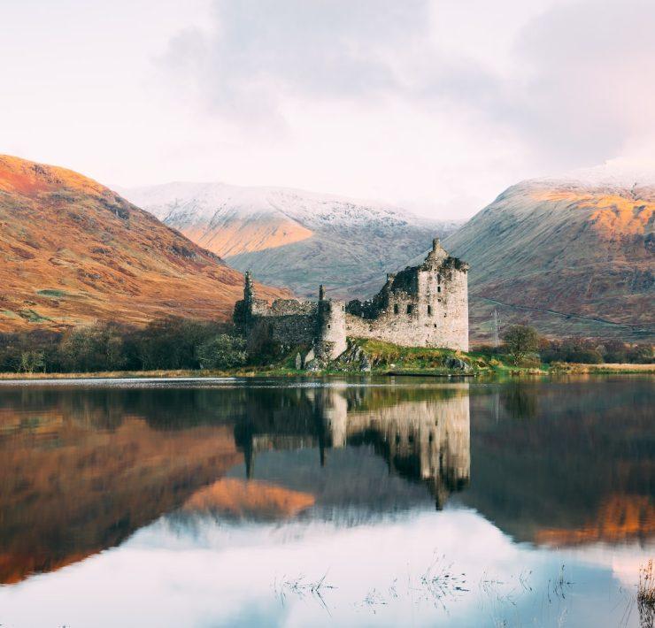 gray concrete building near lake under white sky during daytime