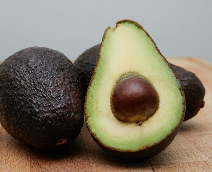 sliced avocado fruit on brown wooden table