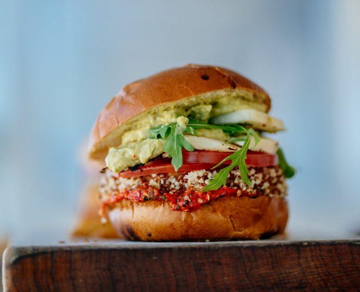 selective focus photography of hamburger with sliced tomatoes and vegetables
