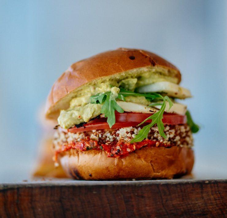 selective focus photography of hamburger with sliced tomatoes and vegetables