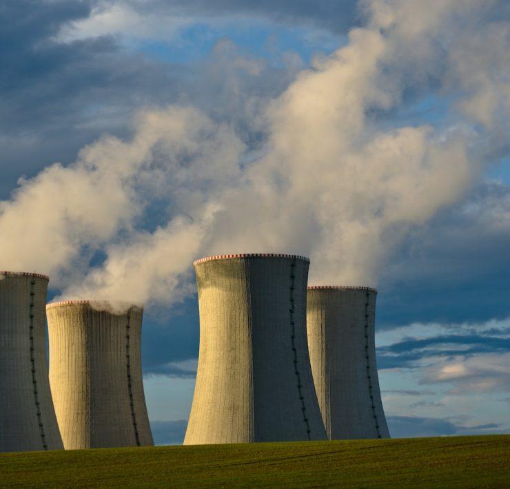 gray concrete towers under white clouds and blue sky during daytime