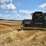 green and brown metal machine on brown grass field under blue sky and white clouds during