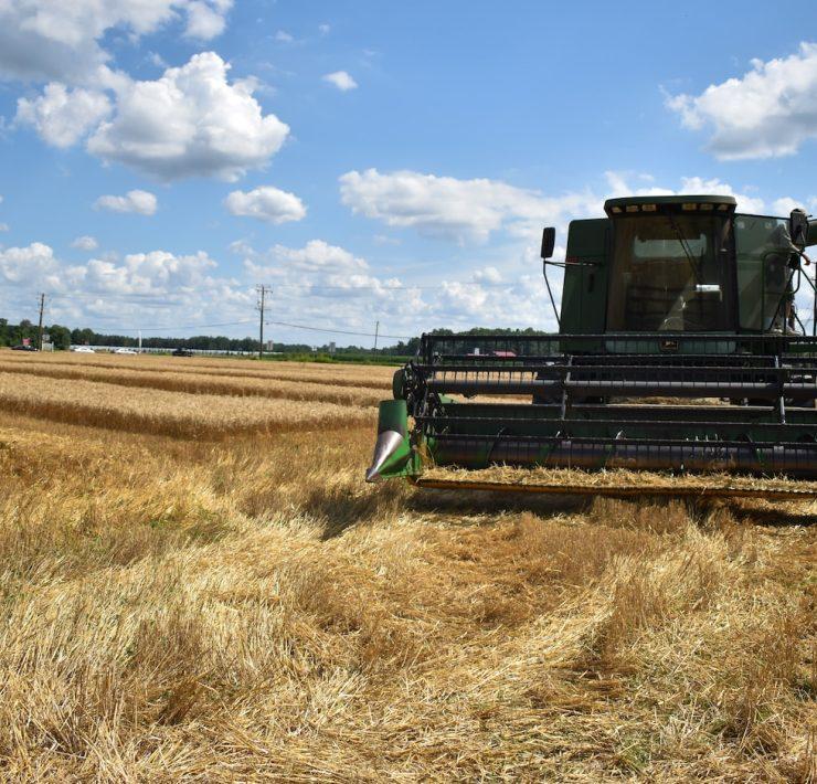 green and brown metal machine on brown grass field under blue sky and white clouds during