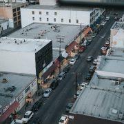 gray asphalt road between of car parking on sidewalks during daytime