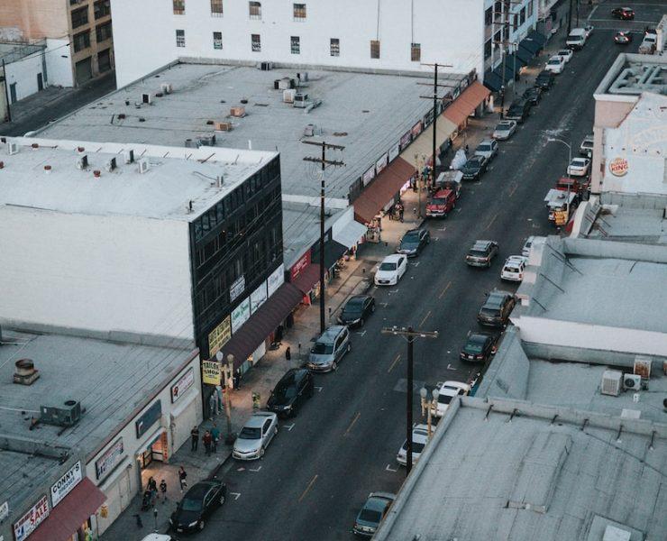 gray asphalt road between of car parking on sidewalks during daytime