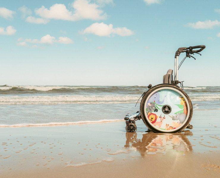 a wheel chair sitting on top of a sandy beach