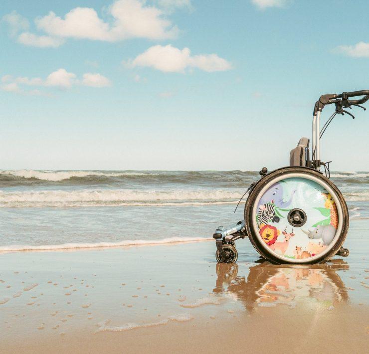 a wheel chair sitting on top of a sandy beach