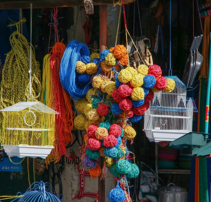 red blue and yellow knit textile on brown wooden hanging rack