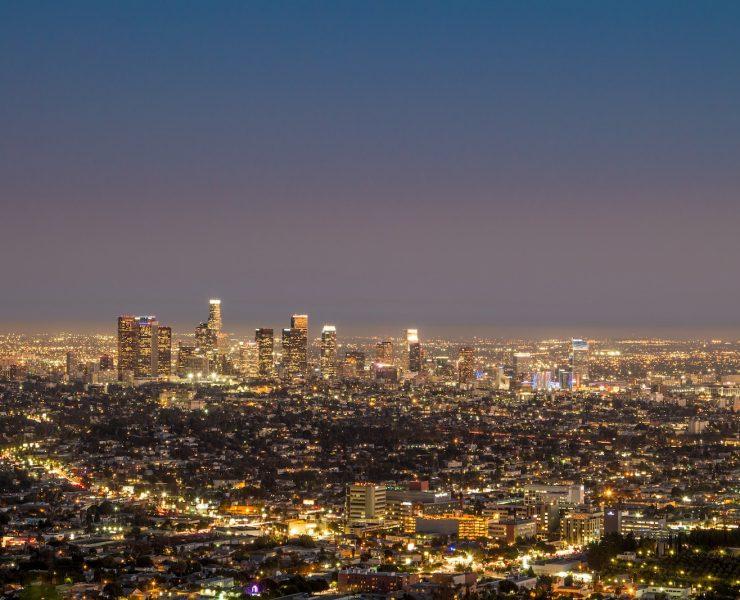 city skyline under blue sky during night time