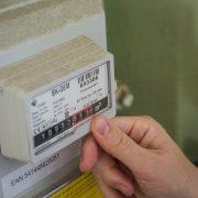 a hand holding a white box with a black and red label