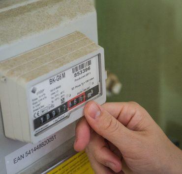 a hand holding a white box with a black and red label