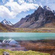 a lake surrounded by mountains under a blue sky